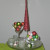 Glass cake plate with tree figurine, martini glass and small glass bowl filled with ornaments, votives and ornaments scattered.