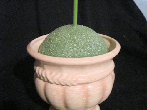 Stick the dowel rod with the yellow boa covered foam ball into the center of the base foam.
