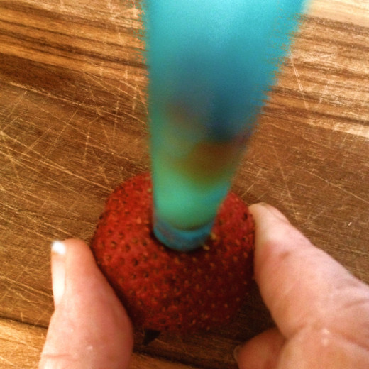 Gently push the straw into the pointed end of the fruit. Lift it once it reaches the bottom.