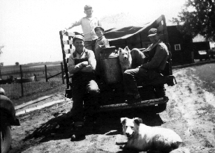 Pete on tailgate of the pickup loaded with milk cans on a Saturday night. We took the milk to town to sell as a cash crop.