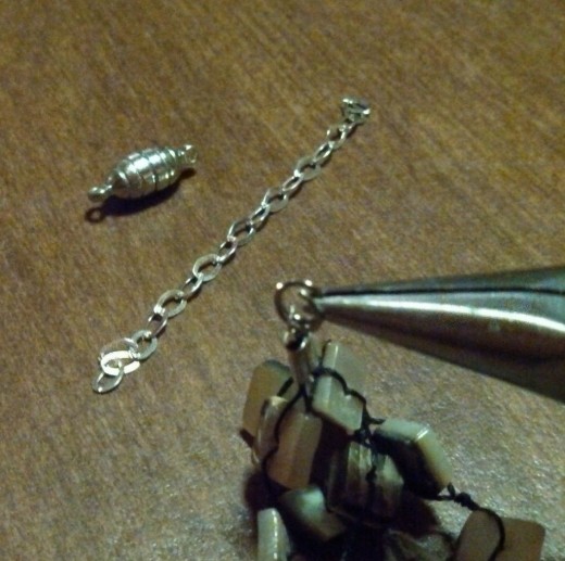 Hold your split ring open using the tip of the chain nose pliers.