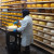 One of the Cheese Affiniers "paints" the first protective coating on a wheel of cheese. One of the Cheese Affiniers "paints" the first protective coating on a wheel of cheese.