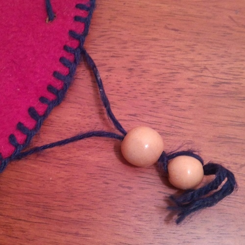 String both beads onto the yarn strands. Knot the outer bead in place.