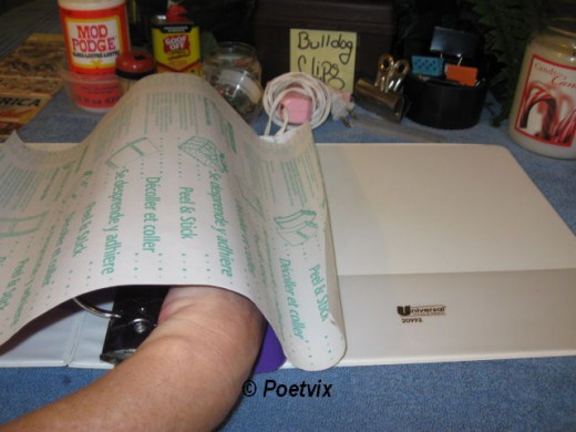 Cut the wide roll Duck Tape to one inch longer than the binder side you want to cover