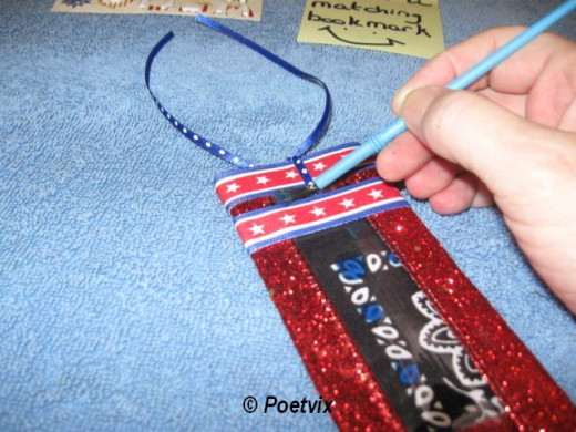String a thin piece of coordinating ribbon through the hole. Tie it off at the top. I had a small open spot right by the hole I punched for the ribbon, so I painted it in with the melted blue crayon. It did not take much.