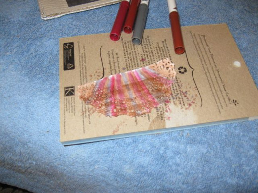 I cut doilies in half and colored alternating stripes of five colors for the inner top trim, the door way trim, and the bottom side trims. Whole doilies with the same pattern were used for the upper corners.