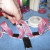 Wrap a strip of tape around each of the small tabs on either side of the midpoint. Wrap the two large tabs that will be the pendant. Leave the hole at the bottom open. Keep the ribbon pulled up like in the picture. Wrap a strip of tape around each of the small tabs on either side of the midpoint. Wrap the two large tabs that will be the pendant. Leave the hole at the bottom open. Keep the ribbon pulled up like in the picture.