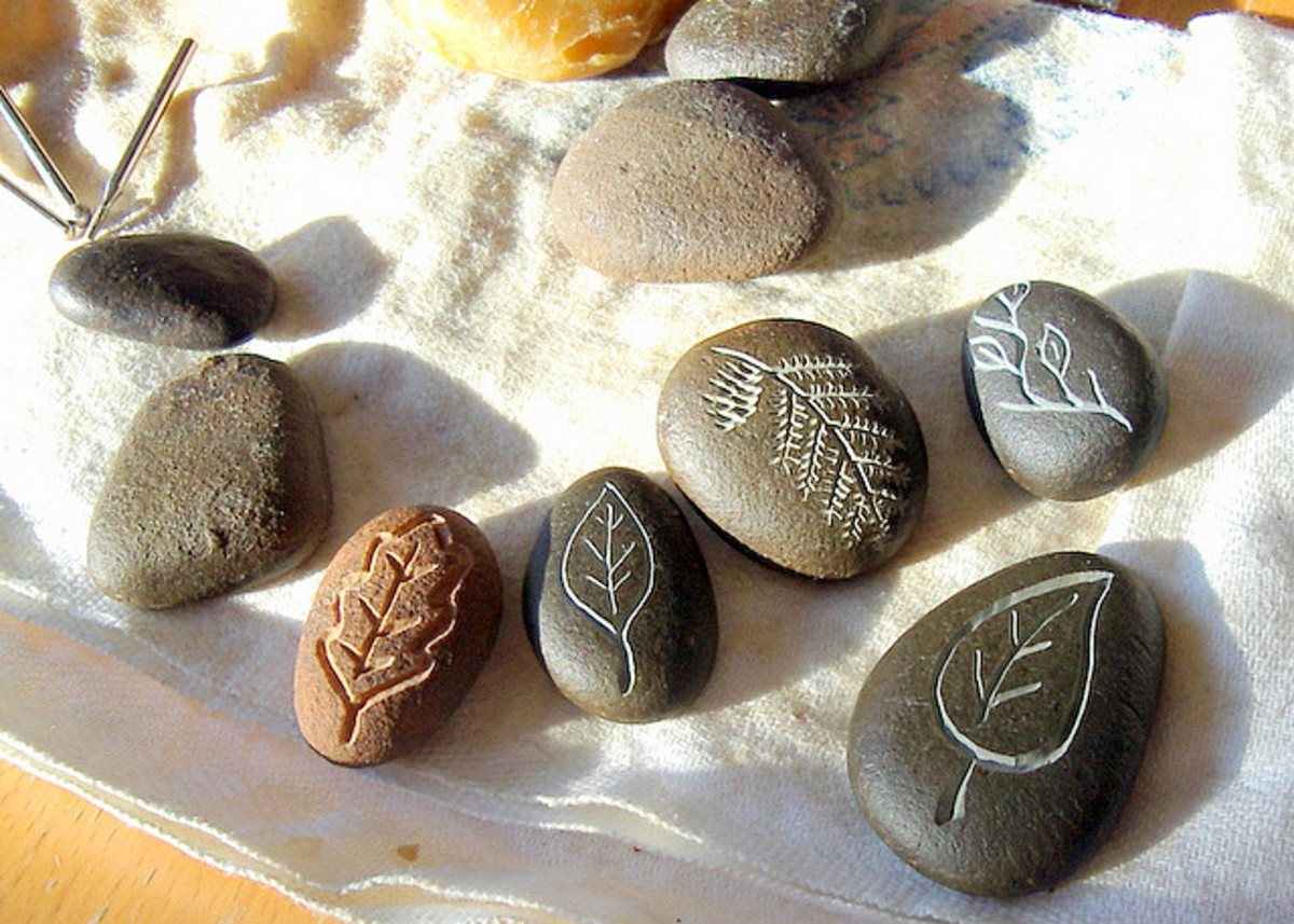 These beach pebbles were carved under running water using diamond bits in a Dremel tool, then beeswax was rubbed onto them to make the carvings more distinct.