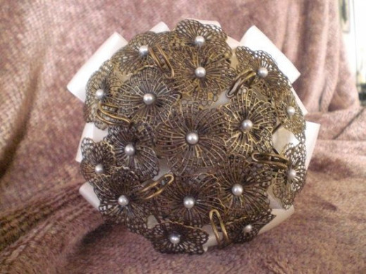 This is a brooch bouquet made from repurposed bronze pins made by AlwaysAfton on Etsy. See the link below.