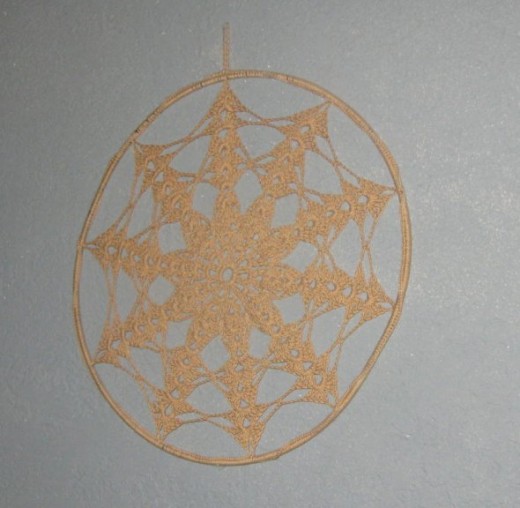 A lace doily was sewn to a circular wire. This looks great on the wall (as shown) or in a window.