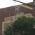 Mother cat carrying kitten ghost sign for OK Storage Co.