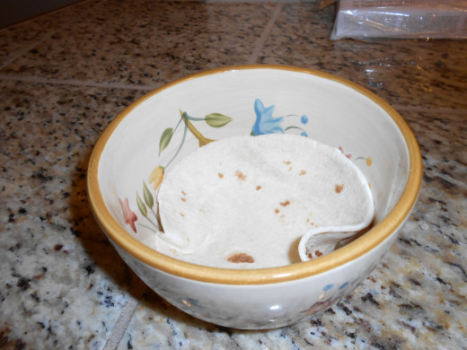 Place a tortilla in a microwave safe bowl and heat in the microwave for one minute.