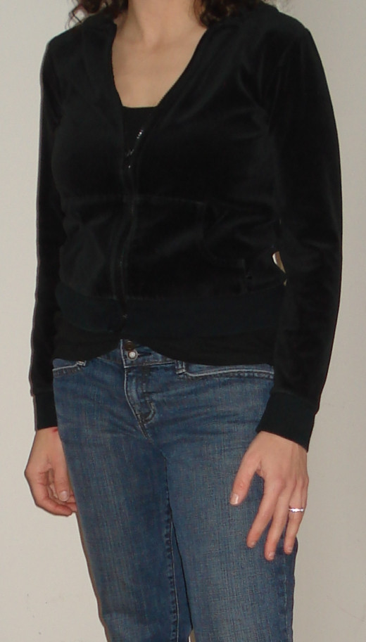 Wearing dark colored clothing on the top half of the body works to minimize the appearance of large breasts.