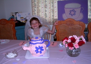 Here's the birthday girl.  Her choice of dress up was a wedding gown.  You can see the tea cup from the "Pin the tea bag on the Tea Cup" game in the background.  Of course fresh flowers made a wonderful addition to the decorations.