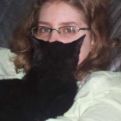 Woman Holding Black Cat to Face