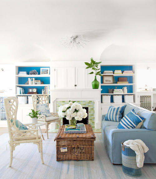 Hues of blue with white are used with a rattan chair and antique wicker trunk.