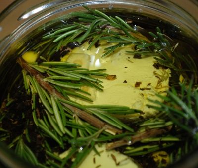 Cover the cheese with oil - it's okay if some of the rosemary sprigs aren't completely covered.